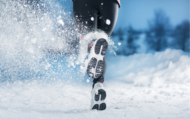 Athlete Frau läuft während des Wintertrainings draußen bei kaltem Schnee Wetter..png
