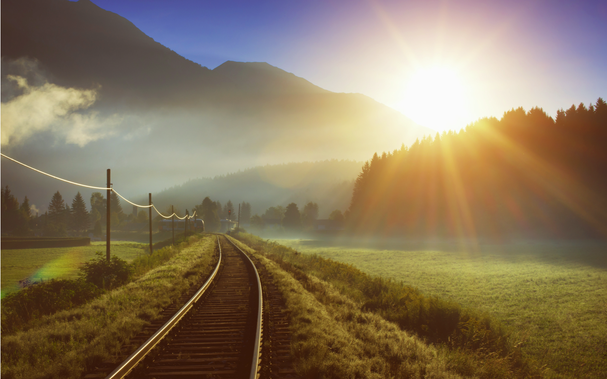 Bahn und Gleis in den Alpen bei Sonnenaufgang
