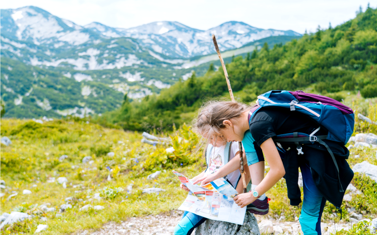 Kinder wandern an einem schönen Sommertag in den Alpen Österreich ruht auf Felsen..png