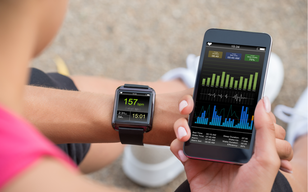 Weibliche Runner schauen sich ihren Herzfrequenzmonitor für mobile und intelligente Armbanduhr an.png
