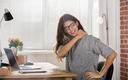 Junge attraktive Geschäftsfrau mit Nackenschmerzen im Büro