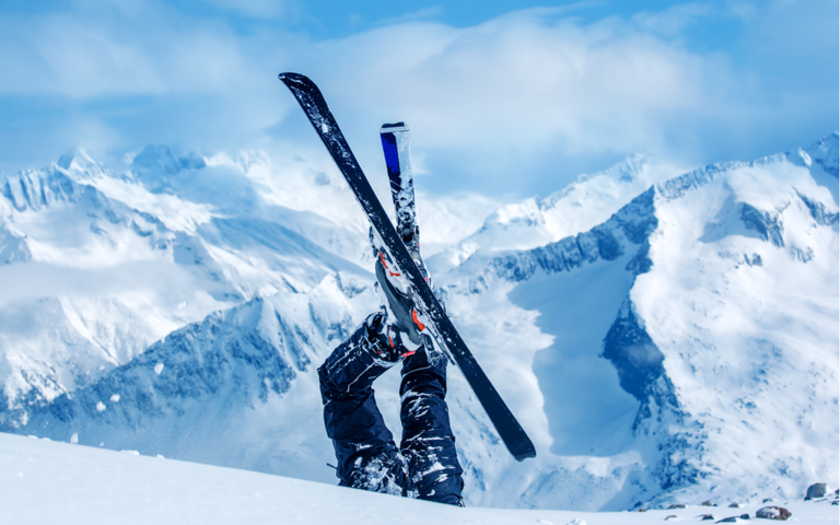 Person mit Ski kopfüber im Schnee in den Bergen