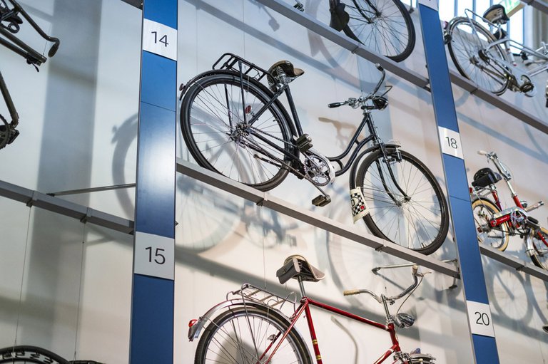 verschiedene Fahrradmodelle stehen in einem blauen Metallgerüst sortiert und sind mit Nummern ausgezeichnet.jpg